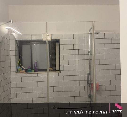 מקלחת עם אריחים לבנים ודלת זכוכית